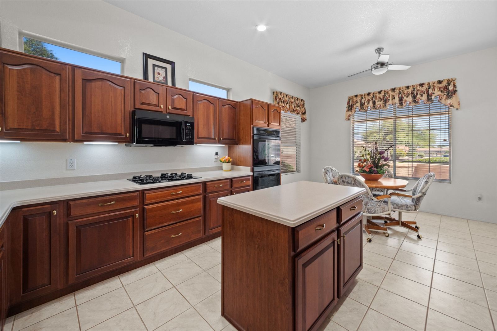 Kitchen with cherry cabinetry, center island and gas cooktop