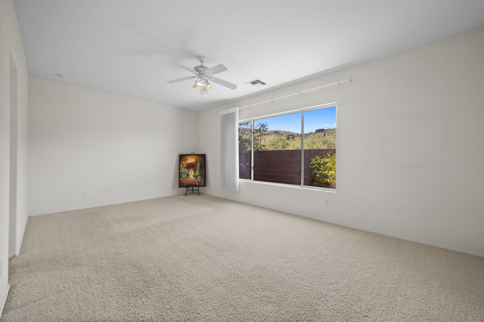 Primary suite with a picture window overlooking the back yard